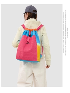 Detail of colorful patchwork backpack with drawstring closure and brand logo