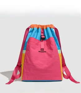 Front view of colorful patchwork nylon drawstring backpack with adjustable pink straps
