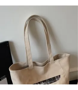 Dettaglio della borsa tote in tela beige con finiture a scacchi e spalline lisce