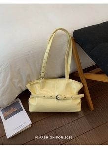 Dettaglio della borsa tote gialla in pelle lucida stropicciata con fibbie eleganti