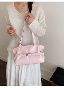 Vista dettagliata della borsa tote rosa lucida con fibbie e trama in pelle stropicciata