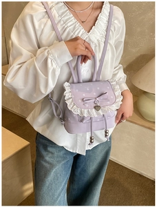 Détail du sac à dos lilas avec bordure en dentelle blanche et nœud décoratif élégant