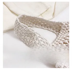 Close-up of beige woven tote bag handle showing high-density cotton rope craftsmanship