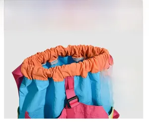 Detail showing the drawstring closure with pink high-density webbing on the nylon backpack