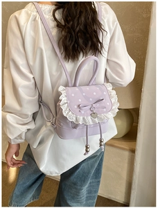 Détail d'un sac à dos lavande à pois avec bordure en dentelle et un nœud