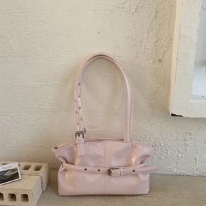 Dettaglio della borsa tote in pelle verniciata rosa chiaro con fibbie metalliche argentate