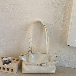 Dettaglio della borsa tote in pelle verniciata stropicciata crema con occhielli argento