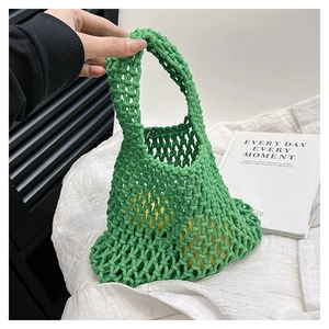Detail of hand-woven green mesh tote bag with integrated handle for beach travel