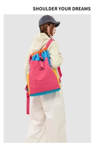Detail of colorful nylon backpack featuring drawstring closure and black buckle strap