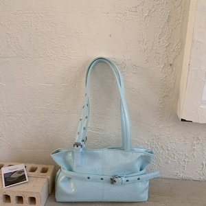 Dettaglio della borsa tote azzurra lucida con fibbie argento e trama in pelle stropicciata