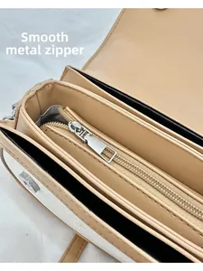 Vue détaillée de la fermeture éclair en métal et des poches intérieures du petit sac