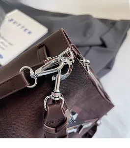 Detail of premium silver buckle and stitching on a vintage brown leather bucket bag