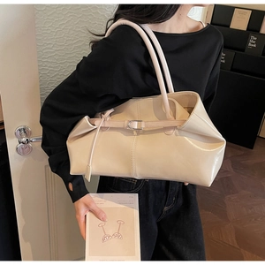 Schicke cremefarbene übergroße Shopper-Tasche mit Metallschnalle getragen von Model