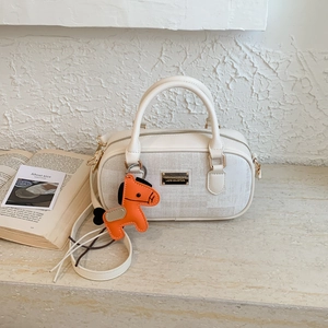 Detail of canvas Boston bag featuring leather trim, brand plaque and horse charm