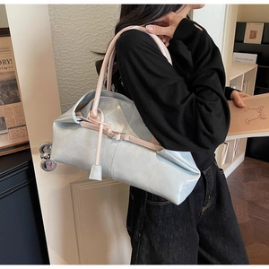 Detailansicht der großen Schultertasche mit weicher Textur und Kontrast-Trageriemen