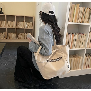 Détail du sac fourre-tout en toile avec poche latérale à carreaux et lettrage Midolai Bag