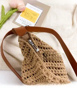 Detail of hand-woven tote bag showing the silver zipper and leather strap texture