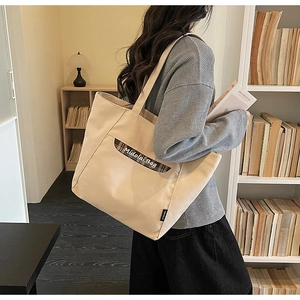 Vue détaillée du grand sac cabas en toile beige avec sangles à carreaux marron