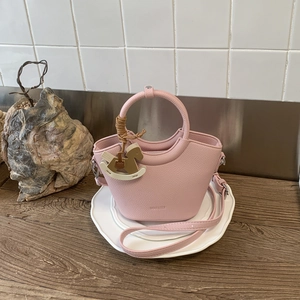 Detail der rosa Leder-Beuteltasche mit NO FILTER-Prägung und hölzernem Pferdeanhänger