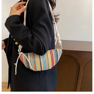 Détail d'un sac tressé coloré avec bandoulière en corde blanche et motif rayé vif