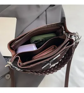 Close-up of brown leather handbag interior showing multiple compartments and storage capacity