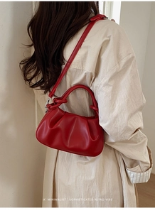 Modella che indossa una borsa a nuvola rossa increspata con design a tracolla e a mano