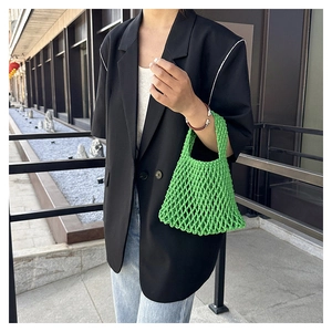 Close-up of bright green hollow woven net bag with thick cotton rope mesh texture