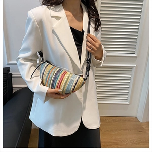 Détail d'un sac croissant tissé coloré avec une bandoulière en cuir noir noué à la main
