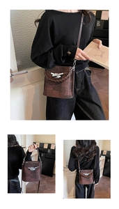 Detail of dark brown textured bucket bag featuring silver lock and dual strap options