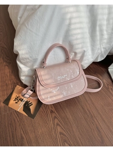 Détail du sac à bandoulière rose avec texture pailletée et finitions argentées