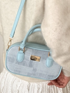 Chic light blue Boston handbag for women featuring a textured fabric and gold hardware