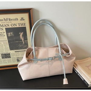 Detailaufnahme der pinkfarbenen Tasche mit blauen Trägern und feiner Ledertextur