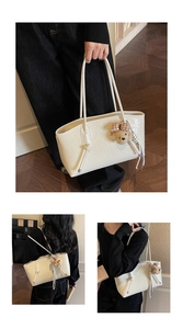 Detail of cream tote bag in gloss cracked leather with a cute plush bear charm