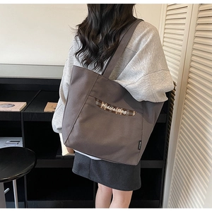 Dettaglio borsa tote in tela grigio scuro con tasca a quadri e ricamo Midolai Bag