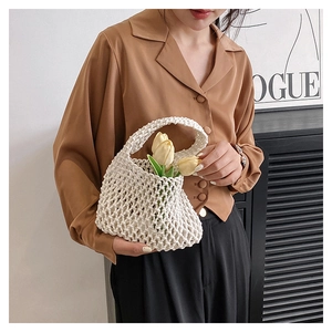 Detailed macro view of white hand-woven cotton mesh bag with integrated round handle