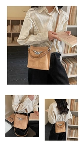 Detail view of the vintage light brown bucket bag featuring woven handle and metallic clasp
