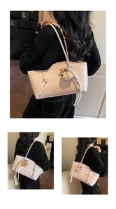 Detail of pink embossed leather tote bag with a cute bear plush charm and long straps