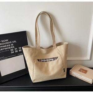Dettaglio della borsa tote in tela beige con tasca scozzese e consistenza elegante