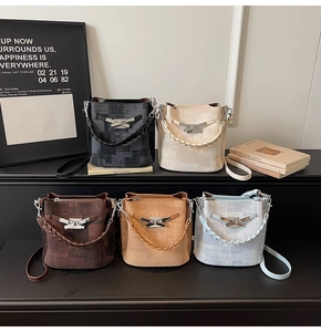 Detail of diverse bucket bags with woven handles and stylish metallic bow buckles