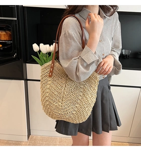Detail of hand-woven V-pattern straw tote with premium brown leather handles and tulips