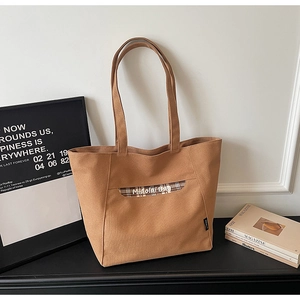 Dettaglio di una borsa tote marrone in tela con manici a quadri e scritta Midolai BAG