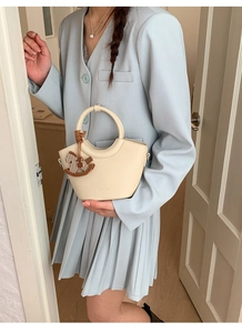 Schicke cremefarbene Lederhandtasche mit Rundgriff und gestreiftem Pferdeanhänger
