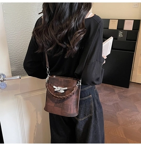 Detail of dark brown vintage bucket bag with wood-grain texture and woven handle