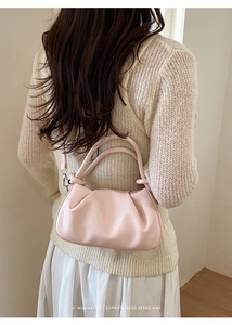 Vista posteriore della modella con borsa a mano rosa chiaro a pieghe e tracolla regolabile