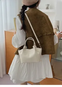 Elegant cream pleated bucket bag worn by model in a modern interior setting