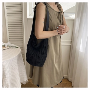 Close-up of black crochet tote bag with hollow mesh design and flat shoulder strap