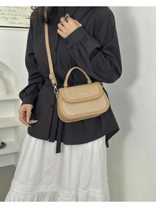Détail du sac à main en similicuir beige avec texture verticale et bandoulière réglable