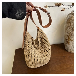 Detail view of rustic woven tote bag with premium brown leather strap and metal buckle