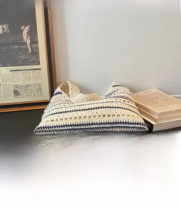 Detail of hand-woven cream tote bag with navy stripes and durable crochet texture