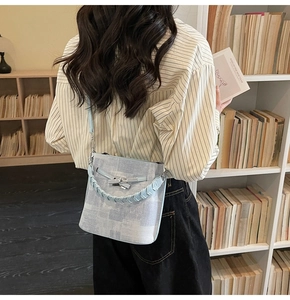 Detail of light blue abstract textured bucket bag with woven handle and silver lock